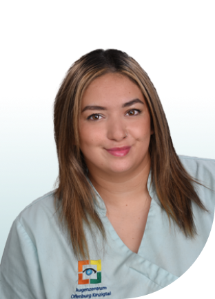Frau mit schulterlangem, braunem Haar trägt weiße Arbeitskleidung mit Logo des Augenzentrums Offenburg Kinzigtal.
